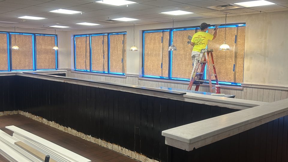 professional-painter-paints-trim-in-office-building