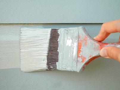 paint brush gliding across exterior siding